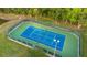 Aerial view of well-maintained tennis court surrounded by lush landscaping in a private setting at 10577 Down Lakeview Cir, Windermere, FL 34786