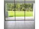 The patio features large sliding glass doors leading to a spacious backyard with green grass and trees at 1134 Pando Loop, Orlando, FL 32824