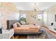 Stylish bedroom with a unique hanging chair, modern light fixture, and chic geometric wallpaper accent wall at 11689 Hampstead St, Windermere, FL 34786