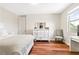 A calm bedroom with hardwood floors, a white dresser, and window overlooking the exterior landscape at 11689 Hampstead St, Windermere, FL 34786