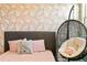 Cozy bedroom features patterned wallpaper, contemporary bed frame, and a comfortable hanging chair at 11689 Hampstead St, Windermere, FL 34786
