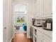 Butler pantry with white cabinets, countertop appliances and wine cooler at 11689 Hampstead St, Windermere, FL 34786