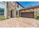 Beautiful home with a stone-accented facade, two-car garage, brick-paved driveway, and manicured landscaping at 11689 Hampstead St, Windermere, FL 34786