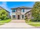 Charming two-story home featuring a stone facade, well-manicured lawn, and a paved driveway leading to the entrance at 11689 Hampstead St, Windermere, FL 34786