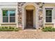 Elegant front entrance with a stone archway, dark wood door, and well-maintained landscaping at 11689 Hampstead St, Windermere, FL 34786