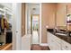 A hallway leading to a bathroom with granite countertops and a walk-in closet with built-in shelving at 11689 Hampstead St, Windermere, FL 34786