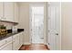 Hall view of the laundry room with plenty of cabinet space and black countertops at 11689 Hampstead St, Windermere, FL 34786