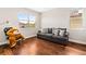 Inviting living room featuring a comfortable gray sofa, a playful teddy bear on a chair, and hardwood flooring at 11689 Hampstead St, Windermere, FL 34786