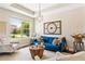 Bright living room with a blue sofa, stylish decor, and a large window overlooking the front yard at 11689 Hampstead St, Windermere, FL 34786
