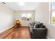 Bright living room with hardwood floors, a comfortable gray sofa, and a large window view at 11689 Hampstead St, Windermere, FL 34786