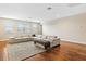 Bright living room features hardwood floors, large sectional, and ample natural light from the large windows at 11689 Hampstead St, Windermere, FL 34786
