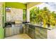 Well-equipped outdoor kitchen with stainless steel appliances, granite countertops, and a built-in grill at 11689 Hampstead St, Windermere, FL 34786