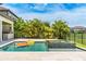 Relaxing backyard oasis with a pool, jacuzzi, outdoor kitchen, and lush tropical landscaping at 11689 Hampstead St, Windermere, FL 34786