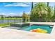 Backyard pool and jacuzzi surrounded by lush landscaping with views of a tranquil lake at 11689 Hampstead St, Windermere, FL 34786