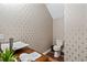 Stylish powder room featuring patterned wallpaper, a modern sink, and a sleek toilet at 11689 Hampstead St, Windermere, FL 34786