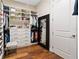 Large walk-in closet with custom shelving, drawers, and a full-length mirror at 11689 Hampstead St, Windermere, FL 34786