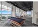Community game room with a billiards table, comfortable seating, and scenic lake views through expansive windows at 150 E Robinson St # 409, Orlando, FL 32801