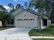 Charming single-story home with a two-car garage, nice landscaping and a well-manicured lawn at 1920 Commander Way, Kissimmee, FL 34746