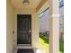 Inviting front entrance featuring a black door, neutral walls, and a covered porch area at 1920 Commander Way, Kissimmee, FL 34746