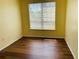 Bright bedroom featuring hardwood floors and a window allowing natural light to fill the space at 1980 Erving Cir # 107, Ocoee, FL 34761