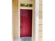 Close-up of a red front door with a welcome mat at the entrance at 1980 Erving Cir # 107, Ocoee, FL 34761
