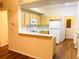 Kitchen features light wood cabinets, white appliances, and a breakfast bar at 1980 Erving Cir # 107, Ocoee, FL 34761