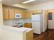 Kitchen with light wood cabinets, white appliances, and white countertops at 1980 Erving Cir # 107, Ocoee, FL 34761