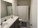 Bright bathroom featuring double sinks, a large mirror, and a shower with curtain at 2232 Tay Wes Dr, St Cloud, FL 34771