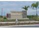 An inviting community sign with stone accents, set amidst lush landscaping and palm trees at 2232 Tay Wes Dr, St Cloud, FL 34771