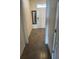 A well-lit hallway with tile flooring leading to a white front door with a mirror accent at 2232 Tay Wes Dr, St Cloud, FL 34771