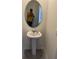 Elegant powder room featuring a pedestal sink and an oval mirror for a touch of sophistication at 2232 Tay Wes Dr, St Cloud, FL 34771