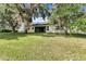 Lush backyard with mature trees, screened lanai, and tranquil setting for outdoor living at 2425 Rambling Oaks Way, Kissimmee, FL 34746