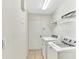 Laundry room featuring a modern washer and dryer with tiled floors and shelves at 2425 Rambling Oaks Way, Kissimmee, FL 34746