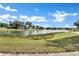 Picturesque view of a serene pond surrounded by lush greenery and neighborhood homes at 2425 Rambling Oaks Way, Kissimmee, FL 34746