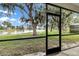 Screened porch with a peaceful view of the lake, trees, and green space at 2425 Rambling Oaks Way, Kissimmee, FL 34746