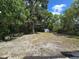 A spacious backyard featuring mature trees, a storage shed and a fire pit at 247 S Marydell Ave, Deland, FL 32720