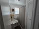 Clean bathroom with a pedestal sink, neutral-toned shower curtain, and ample storage at 247 S Marydell Ave, Deland, FL 32720
