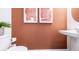 Powder room with modern pedestal sink, wall art, and toilet at 2592 Penguin Blvd, Davenport, FL 33837