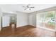 Bright living room featuring wood floors, a ceiling fan, and sliding glass doors that bring in natural light at 2827 Sanka Dr, Orlando, FL 32826