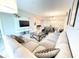 Cozy living room featuring a large sofa, TV, and view of the dining and kitchen areas at 3120 Paradox Cir # 101, Kissimmee, FL 34746