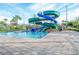 Community pool area with a large waterslide, palms, and ample lounge space, offering fun for all ages at 3120 Paradox Cir # 101, Kissimmee, FL 34746