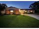 Charming single-story home featuring a well-manicured lawn and inviting curb appeal at twilight at 3131 Lowndes Dr, Winter Park, FL 32792