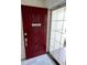 Close-up of a stylish red front door with a decorative glass sidelight at 3131 Lowndes Dr, Winter Park, FL 32792