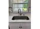 Modern kitchen sink with stainless steel faucet and quartz countertops under a window at 3131 Lowndes Dr, Winter Park, FL 32792
