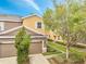 Two-story home featuring a two-car garage, tan and brown stucco, manicured landscaping, and lovely curb appeal at 3166 Rodrick Cir, Orlando, FL 32824