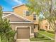 Two-story home featuring a two-car garage, tan and brown stucco, manicured landscaping, and lovely curb appeal at 3166 Rodrick Cir, Orlando, FL 32824