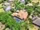 Expansive aerial view showcasing a home's layout, screened pool, and surrounding neighborhood with mature trees at 32613 View Haven Ln, Sorrento, FL 32776