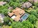 Beautiful aerial shot of a home boasting a tile roof, screened pool, and meticulously manicured landscaping at 32613 View Haven Ln, Sorrento, FL 32776