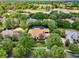 Overhead view of a home near a golf course and lake, enveloped by verdant trees and meticulous landscaping at 32613 View Haven Ln, Sorrento, FL 32776