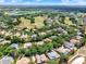 Panoramic aerial shot of a residential area with homes, golf courses, and lakes surrounded by lush greenery at 32613 View Haven Ln, Sorrento, FL 32776